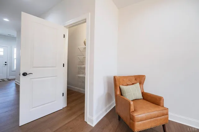 a view of a hallway with wooden floor and closet