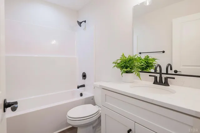 a bathroom with a sink a toilet a mirror and shower