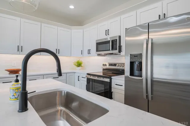 a kitchen with a refrigerator a microwave a sink and cabinets
