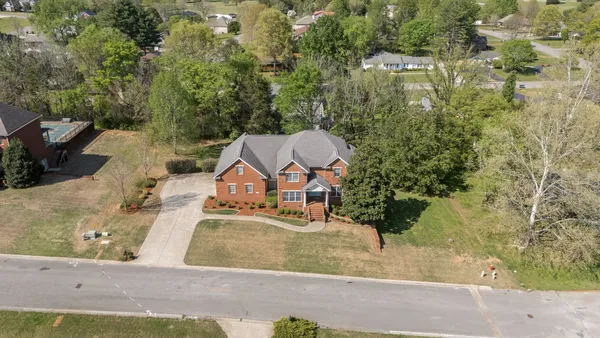 an aerial view of a house with swimming pool and red space
