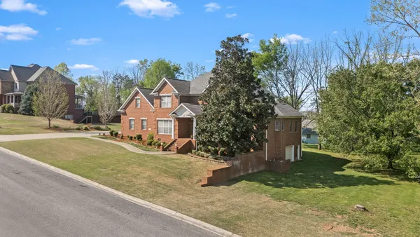 a front view of a house with a yard and trees