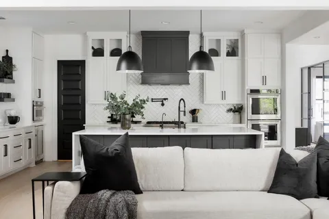 a living room with stainless steel appliances kitchen island granite countertop furniture mirror on the wall and a window