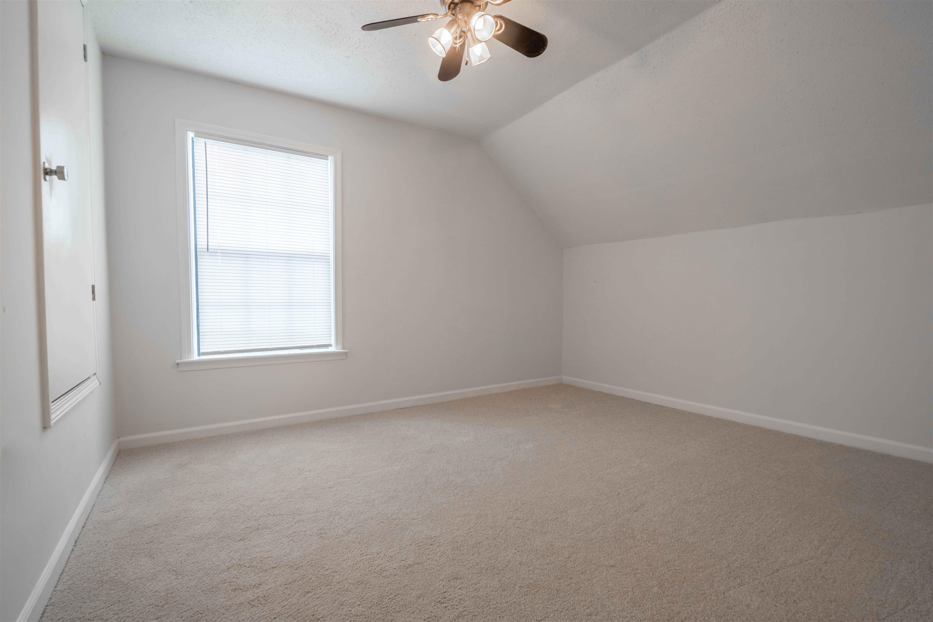 7800 Buck Ridge Cove Memphis, TN 38016 - Photo 30 of 36 Carpeted room featuring an angled ceiling, single window with blinds, baseboard molding, and a ceiling fan with integrated lighting