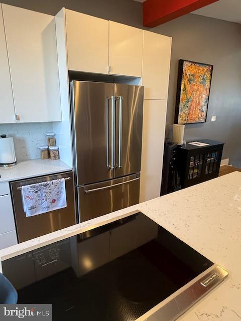 1221 Oates Street Northeast, Unit C Washington, DC 20002 - Photo 12 of 33 a kitchen with stainless steel appliances a refrigerator a stove and white cabinets
