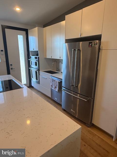 1221 Oates Street Northeast, Unit C Washington, DC 20002 - Photo 7 of 33 a kitchen with stainless steel appliances a refrigerator and a sink