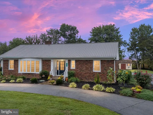 a front view of a house with a yard and outdoor seating