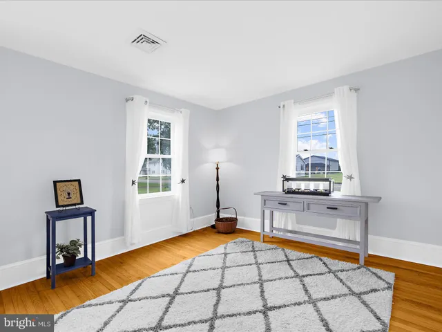 a living room with stainless steel appliances furniture a rug and a window