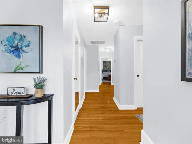 a view of a hallway with wooden floor and a workspace