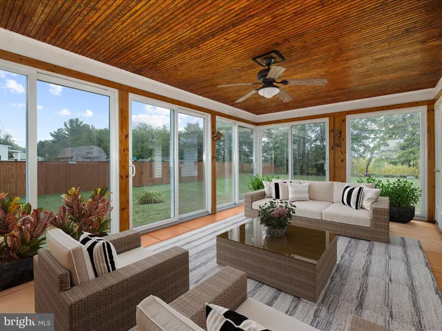 a living room with furniture and floor to ceiling windows