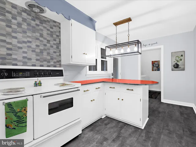 a kitchen with stainless steel appliances granite countertop a dining table chairs and white cabinets