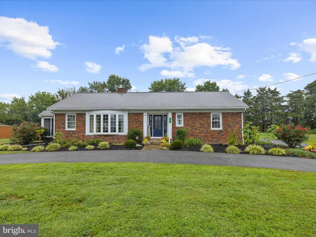 a front view of house with yard and green space
