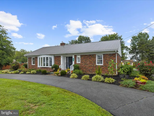 a front view of a house with a garden and outdoor seating