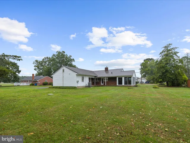 a view of a house with a big yard and large trees
