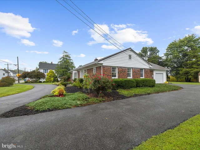 a front view of a house with a yard and potted plants