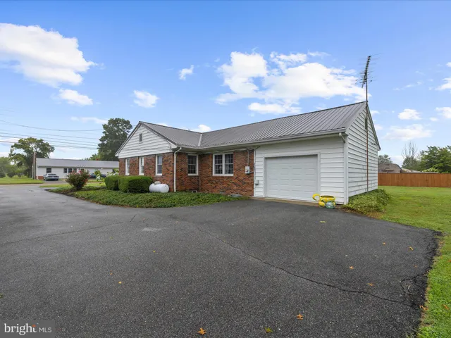 a front view of house with yard and trees in the background