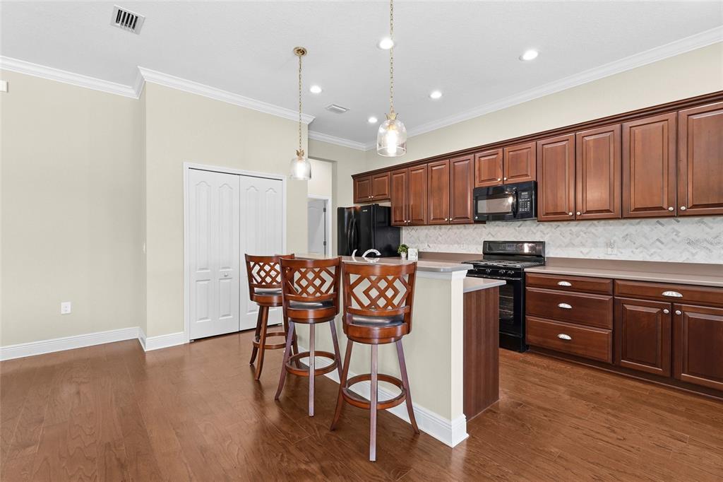 357 Marsh Creek Road Venice, FL 34292 - Photo 10 of 70 a kitchen with stainless steel appliances granite countertop a refrigerator a stove top oven and a sink with wooden floor