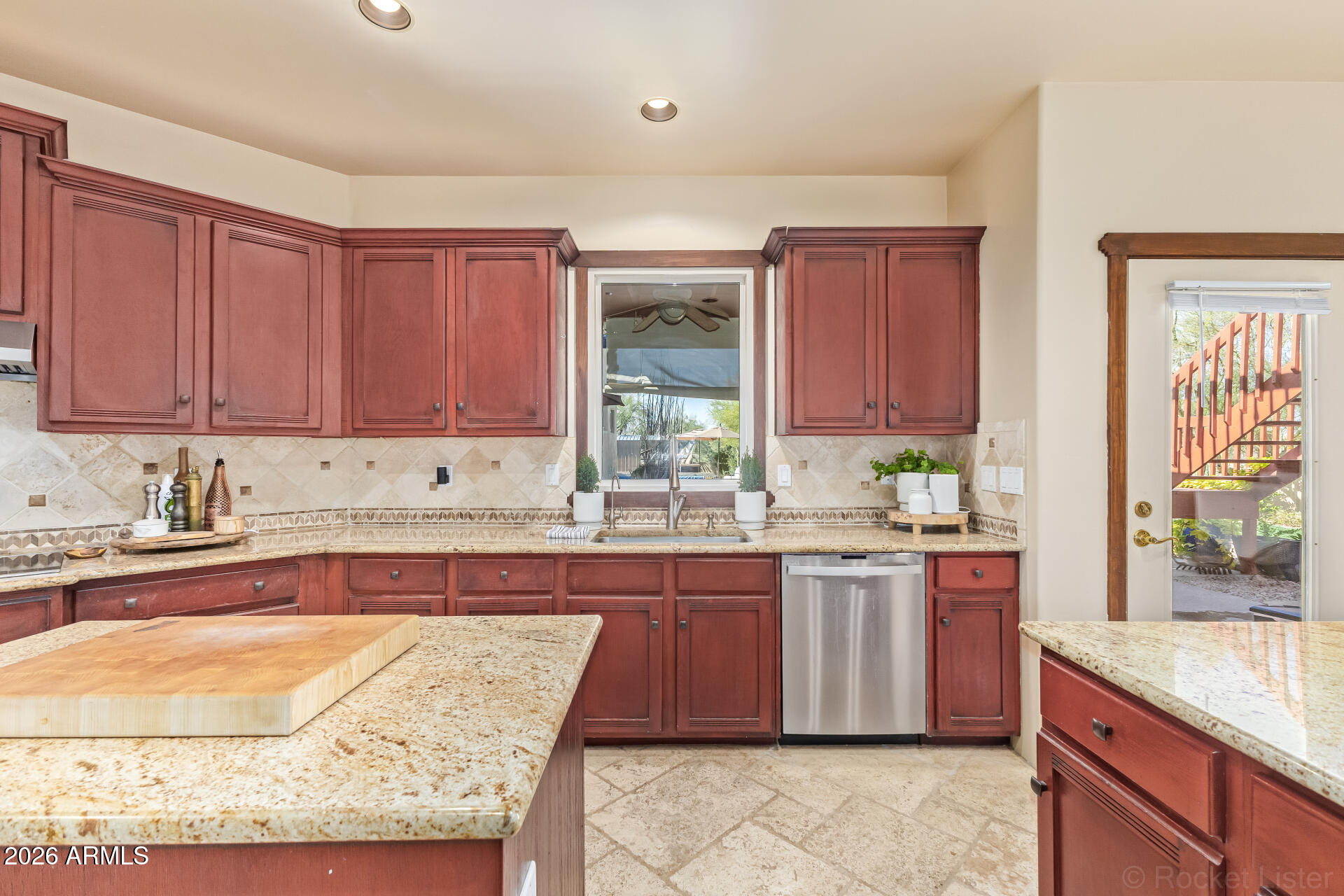 8549 East Bronco Trail Scottsdale, AZ 85255 - Photo 25 of 67 a large kitchen with kitchen island granite countertop wooden cabinets stainless steel appliances a sink and a window