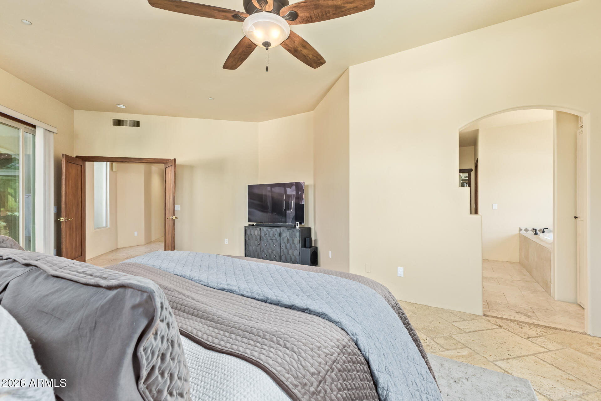 8549 East Bronco Trail Scottsdale, AZ 85255 - Photo 31 of 67 a bedroom with a bed and a chandelier