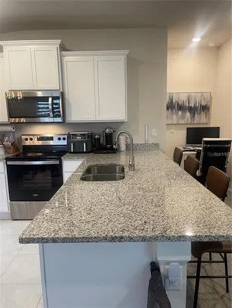 a kitchen with granite countertop a sink a counter top space and appliances