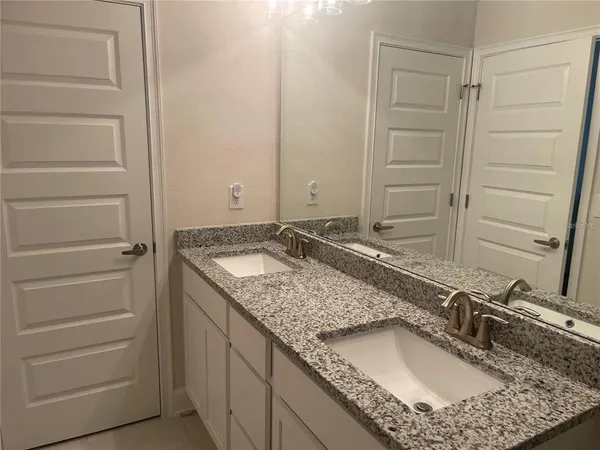 a bathroom with a granite countertop sink and a mirror