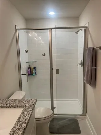 a bathroom with a granite countertop shower and a sink