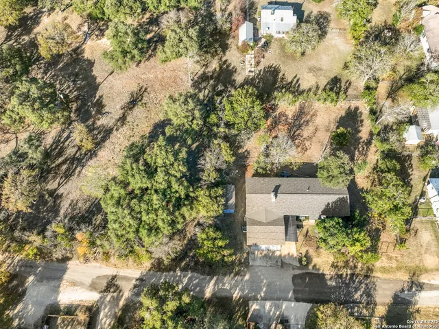an aerial view of a house with yard and outdoor seating