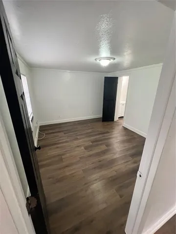 en empty room with wooden floor and fan