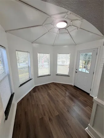 an empty room with wooden floor and staircase