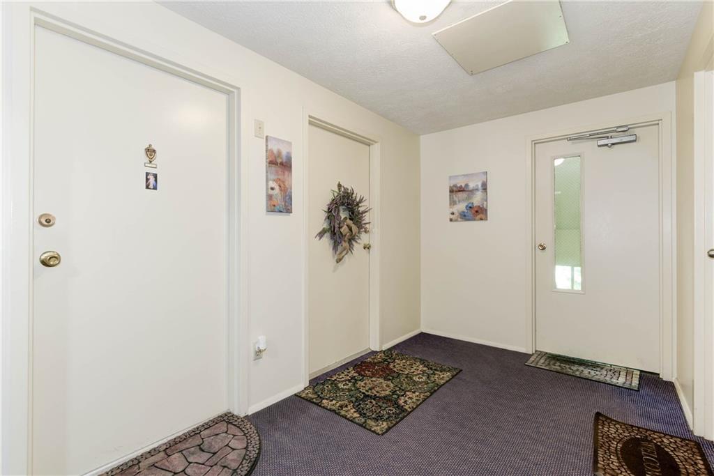 329 Ridge Point Circle, Unit 34B Bridgeville, PA 15017 - Photo 2 of 25 Inside this building, your guests can walk upstairs to the front entrance of this condominium in a cozy decorated hallway.