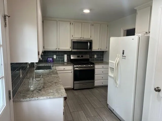 a kitchen with a refrigerator stove and microwave