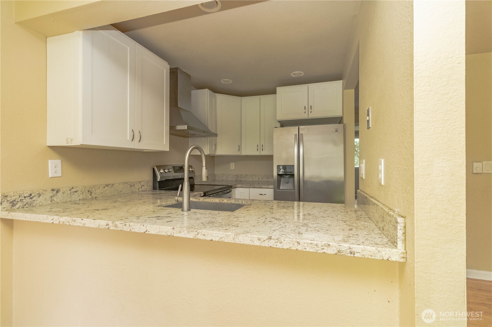 17425 119th Lane Southeast, Unit D12 Renton, WA 98058 - Photo 6 of 25 a kitchen with stainless steel appliances granite countertop a sink refrigerator and cabinets
