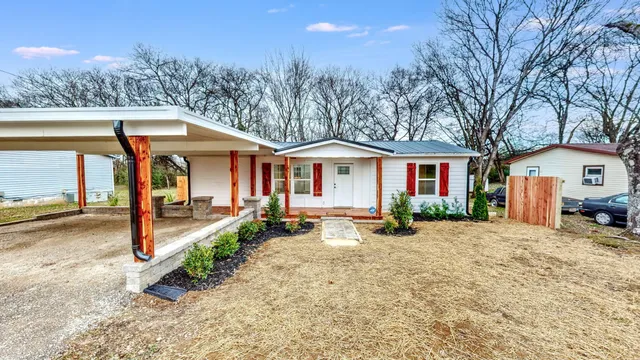 a view of a house with backyard and trees