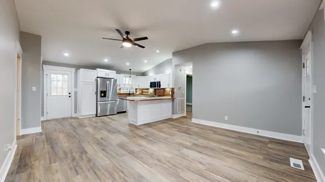 a view of a kitchen with wooden floor and windows
