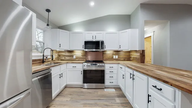 a kitchen with stainless steel appliances granite countertop a stove and a sink