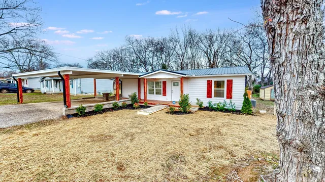 a view of a house with a yard and sitting area