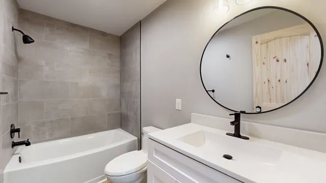 a bathroom with a sink a toilet and a mirror