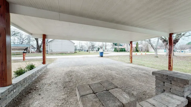 a view of a road with a big yard and large tree