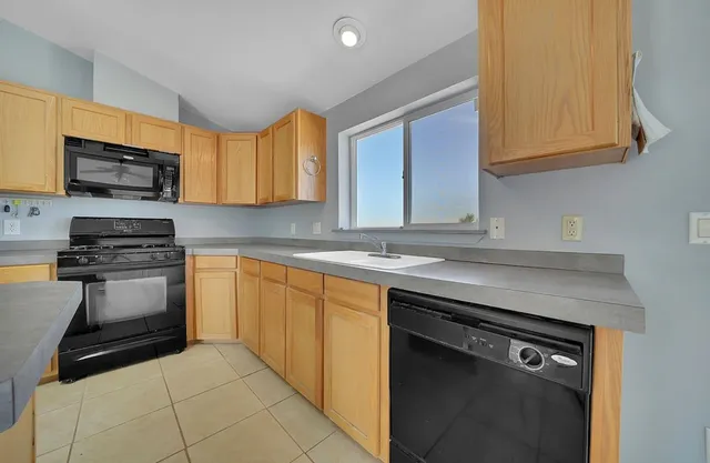 a kitchen with cabinets appliances and a counter top space