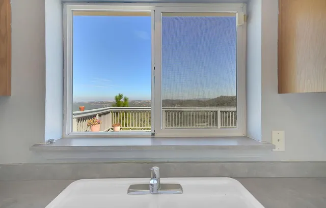 an empty room with a ceiling fan and window