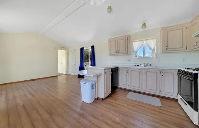 a view of a kitchen with wooden floor and a kitchen