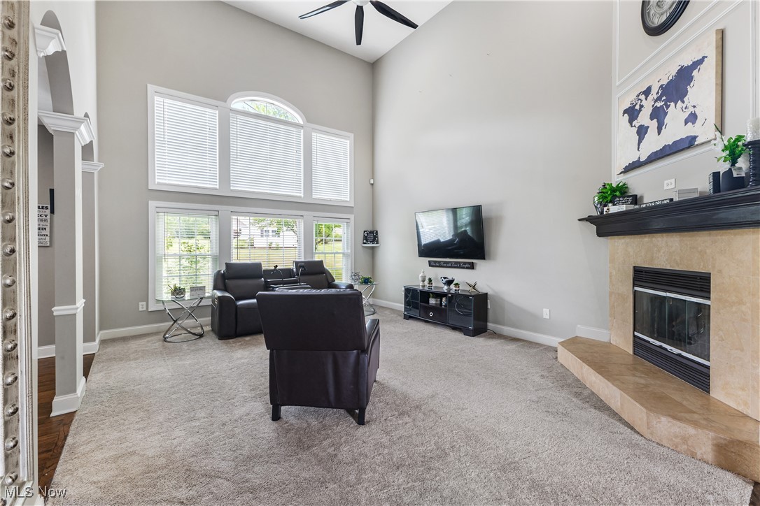 2251 Timber Ridge Trail Streetsboro, OH 44241 - Photo 7 of 48 Living room with a towering ceiling, a tile fireplace, light wood-type flooring, and ceiling fan