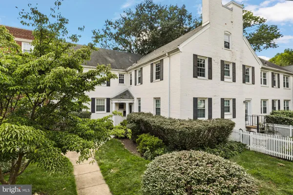 a view of a white house with a yard and plants