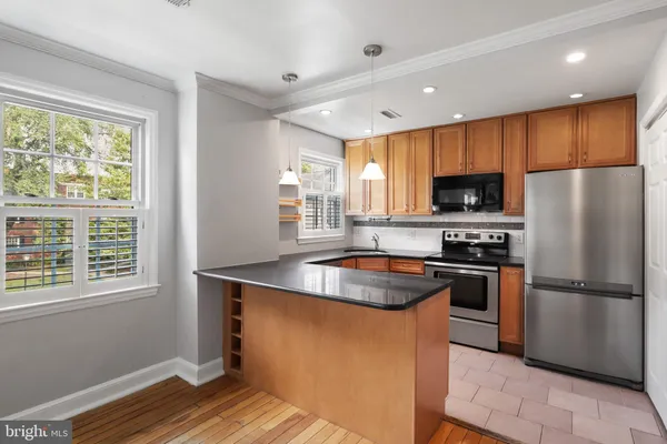 a kitchen with kitchen island granite countertop a sink appliances cabinets and a counter top space