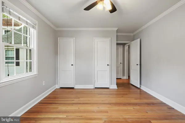 a view of empty room with wooden floor and window