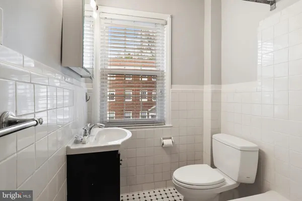 a bathroom with a sink a toilet and mirror