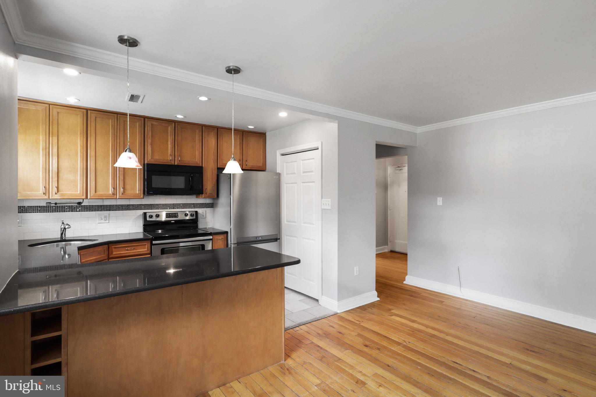 2912 13th Road South, Unit 204 Arlington, VA 22204 - Photo 24 of 32 a kitchen with granite countertop a refrigerator stove top oven and sink