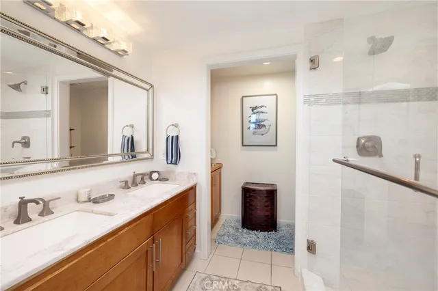 a spacious bathroom with a double vanity sink a mirror and shower