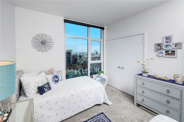 a bedroom with a bed and large window