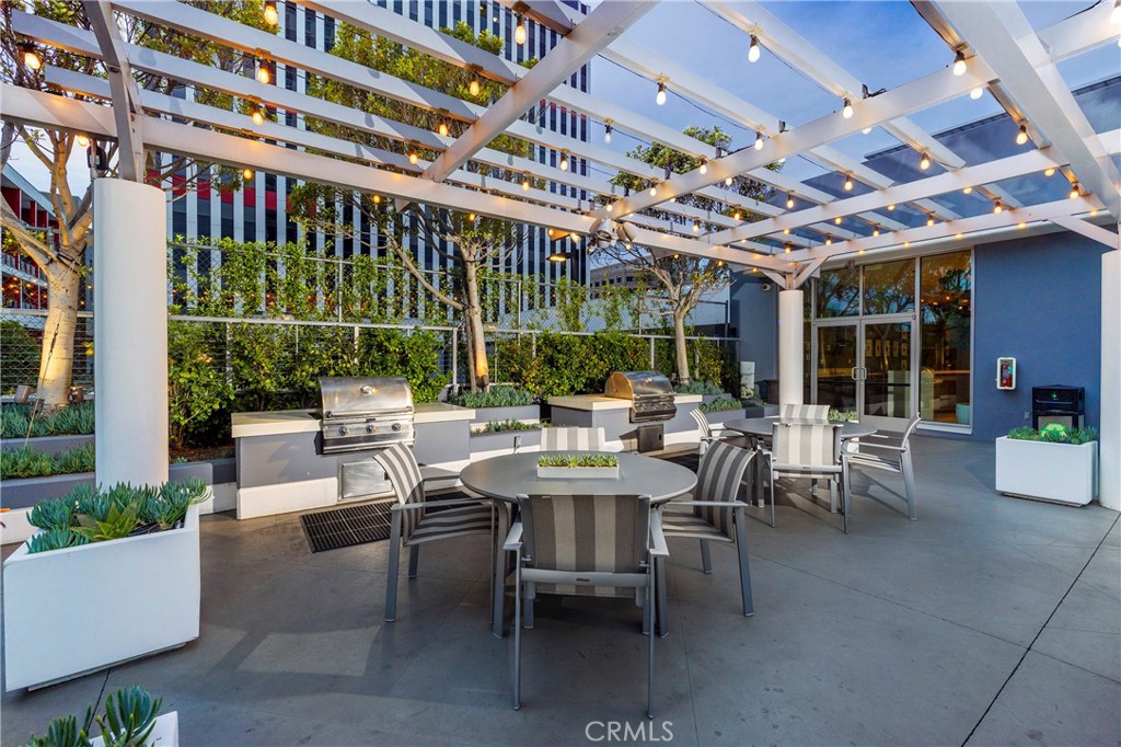 400 West Ocean Boulevard, Unit 902 Long Beach, CA 90802 - Photo 25 of 32 a view of a patio with a table and chairs and potted plants