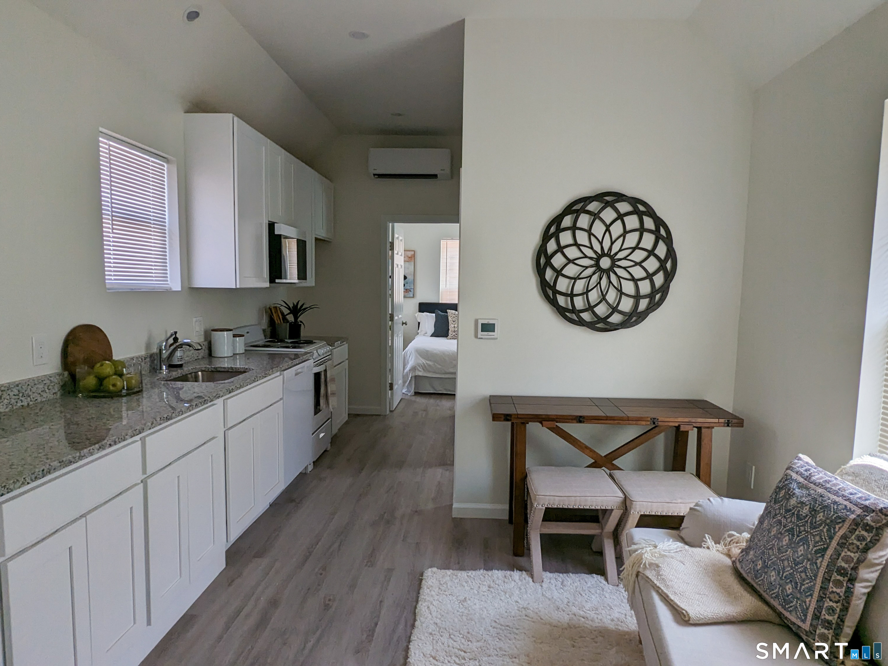 1187 North Broad Street, Unit 1 Meriden, CT 06450 - Photo 2 of 5 a large white kitchen with a stove a sink a dining table and chair